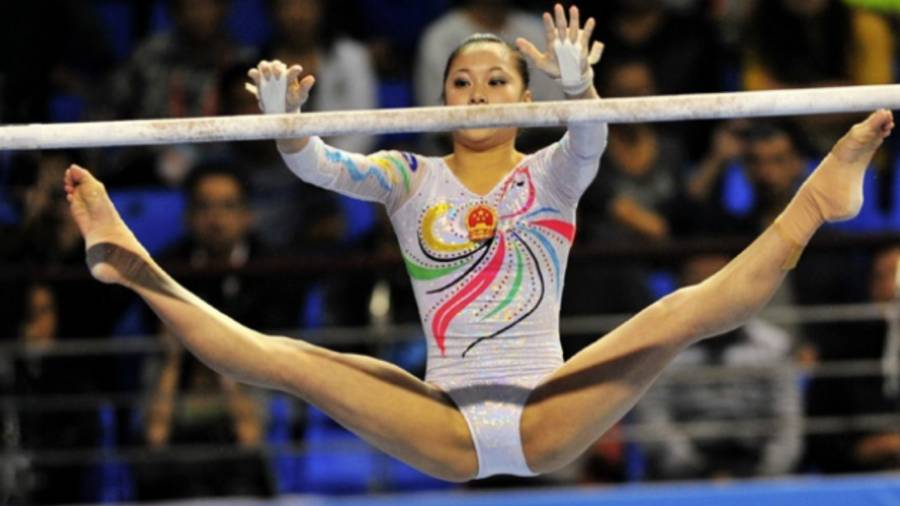 Gymnast wide split on uneven bars