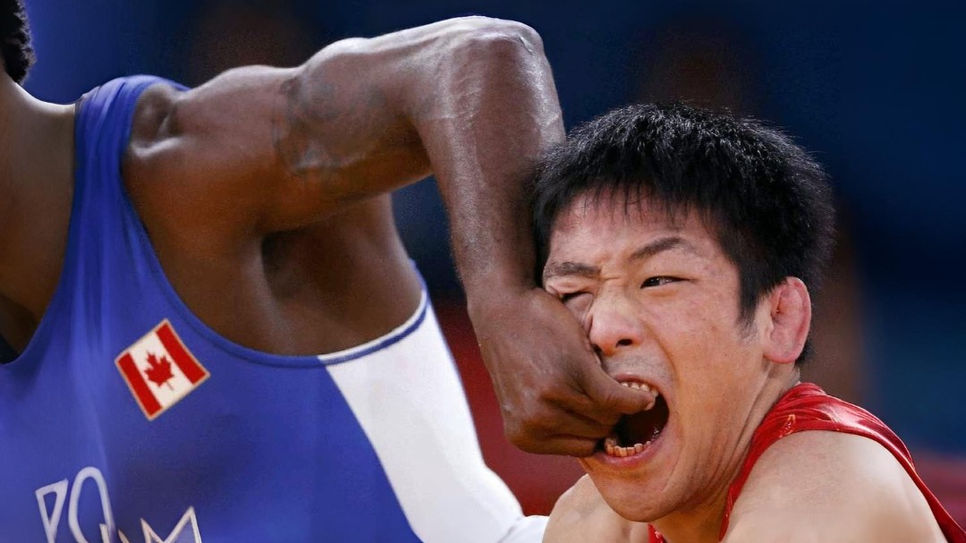 Wrestlers in a scrappy, accidental face grab