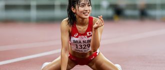 Runner stretching and smiling on the track